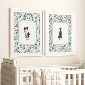 May include: Two framed prints with a white background and a blue and green floral pattern. The prints feature a black and white border collie and a grey Weimaraner dog sitting in a portrait pose. The dog's names are written below each image.