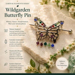 May include: A silver-plated Wildgarden butterfly pin with a wire-wrapped frame, gemstone accents, and dangling crystals. The pin features amethyst, ruby, emerald, peridot, and sapphire gemstones. The butterfly design symbolizes transformation and new beginnings.