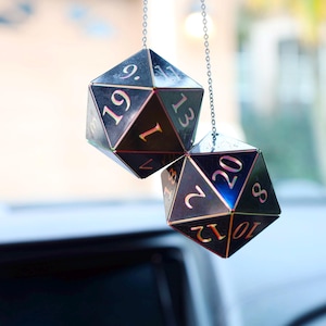 May include: Two black iridescent dice with silver numbers hanging from a silver chain. The dice are a 20-sided die and a 12-sided die.