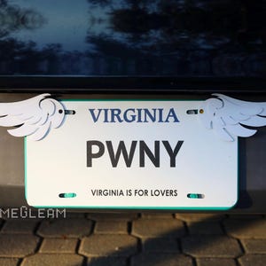 May include: White license plate with the text "VIRGINIA" and "PWNY" with the words "VIRGINIA IS FOR LOVERS" below. The plate has two white angel wings attached to the top corners.