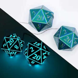 May include: Two black and green 20-sided dice with glowing blue numbers. The dice are connected by a silver chain.