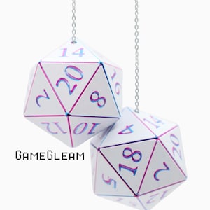 May include: Two white twenty-sided dice hanging from thin silver chains. Each die features iridescent, color-shifting numbers and edges. The text GAMEGLEAM is printed in a black pixelated font to the left of the dice against a plain white background.