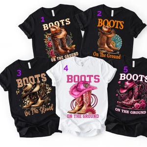 May include: Five t-shirts with the text "BOOTS ON THE GROUND". Four black t-shirts and one white t-shirt feature cowboy boots and hats in various designs. The designs include floral and patterned elements.