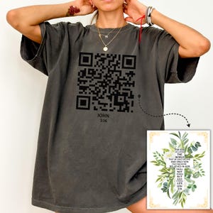 May include: A gray t-shirt with a black QR code and the text "JOHN 3:16". The QR code links to a Bible verse that reads "For God so loved the world that He gave His one and only Son, that whoever believes in Him shall not perish but have eternal life. John 3:16".