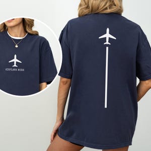 May include: Navy blue t-shirt with a white airplane graphic and the words "AIRPLANE MODE" on the front. The back of the shirt features a white airplane graphic with a vertical line. A casual, comfortable tee.