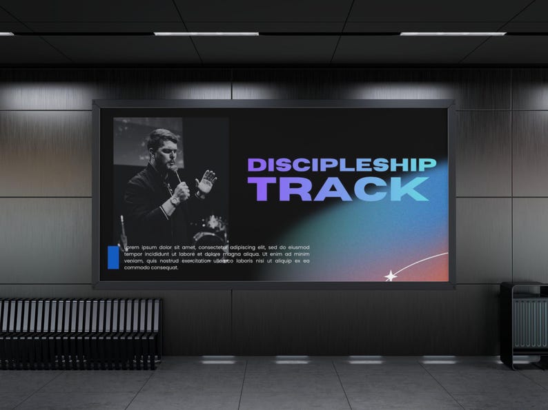 以下が含まれることがあります： 紫と青のグラデーションテキストで「DISCIPLESHIP TRACK」という言葉が表示された大きなデジタルディスプレイ。左側には、マイクに向かって話している男性の白黒画像があります。背景は暗いです。