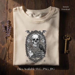 May include: A cream-colored t-shirt featuring a detailed black and white graphic of a human skull, a raven perched on a stack of books, a bottle labeled Poison, and bats, all framed by an intricate lace-like border with small spiders.