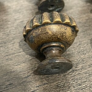 May include: A brass cabinet knob with a fluted design and a round base.