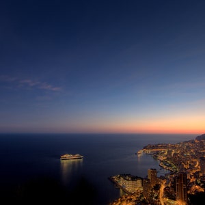 A gorgeous cruise ship on the sea. Rows of lights on the shore light up the night sky. HD computer background picture, xuan cruise ship