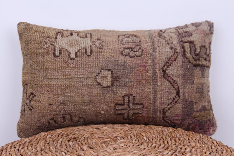 Puede incluir: Una almohada rectangular marr&oacute;n y beige con un patr&oacute;n tejido. La almohada tiene un dise&ntilde;o geom&eacute;trico con acentos marrones y beige.