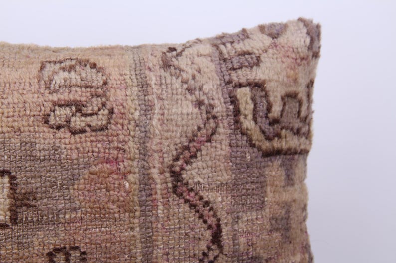 Puede incluir: Primer plano de una almohada decorativa con un patr&oacute;n tejido marr&oacute;n y beige. La almohada tiene una superficie suave y texturizada y un dise&ntilde;o floral sutil.