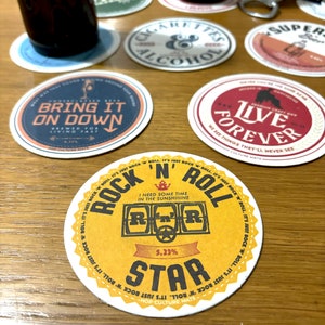 Könnte beinhalten: Runder Untersetzer in Gelb und Schwarz mit dem Text "Rock 'n' Roll" und "Ich brauche etwas Zeit in der Sonne". Der Untersetzer hat auch einen Stern und den Text "5.23% Star".