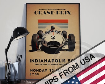 May include: Framed vintage poster for the Indianapolis 500 Grand Prix. The poster features a white race car with the number 2, a driver, and text in a retro style. The poster is in a black frame.