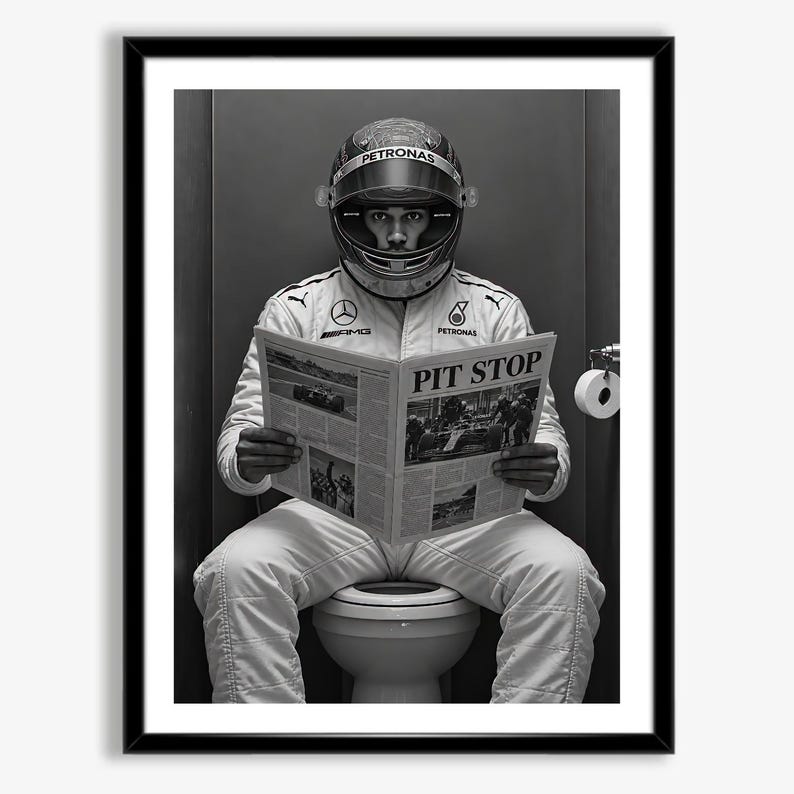 May include: A black and white framed print featuring a race car driver in a full racing suit and helmet sitting on a toilet while reading a newspaper titled PIT STOP. The suit displays Mercedes-AMG and Petronas logos on the chest.