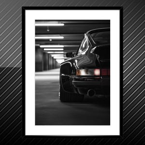 Pode incluir: Um Porsche 911 Turbo preto em uma garagem com pouca luz. O carro está de costas para a câmera, e as luzes traseiras são visíveis. O carro está estacionado em uma fileira de outros carros, e as luzes da garagem são visíveis no fundo.