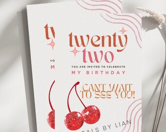 May include: A pink and white birthday invitation with the text "twenty two" in orange and red. The invitation features two red cherries with a disco ball design and the text "Can't wait to see you!" in orange and brown.