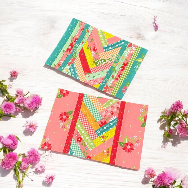 Pu&ograve; includere: Due quadrati di tessuto con un motivo intrecciato di strisce colorate. I quadrati sono su una superficie di legno bianco con fiori rosa.