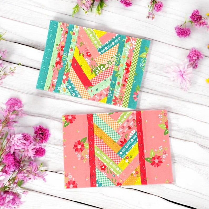 Pu&ograve; includere: Due quadrati di tessuto fatti a mano con un design a patchwork. I quadrati sono fatti di strisce di tessuto colorate in tonalit&agrave; di rosa, giallo, verde e rosso. Il tessuto &egrave; disposto in diagonale. I quadrati sono su uno sfondo di legno bianco.