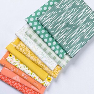 Könnte beinhalten: Eine Sammlung farbenfroher Stoffmuster mit verschiedenen Mustern. Die Stoffe umfassen Punkte, Streifen, Blumenmuster und geometrische Designs in Grün-, Gelb- und Orangetönen. Die Muster sind in einer geschichteten, diagonalen Anordnung angeordnet.