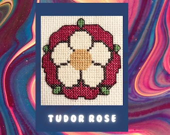 May include: A white flower with a yellow center surrounded by a red circle, with green leaves, on a white background. The text "TUDOR ROSE" is below the image.