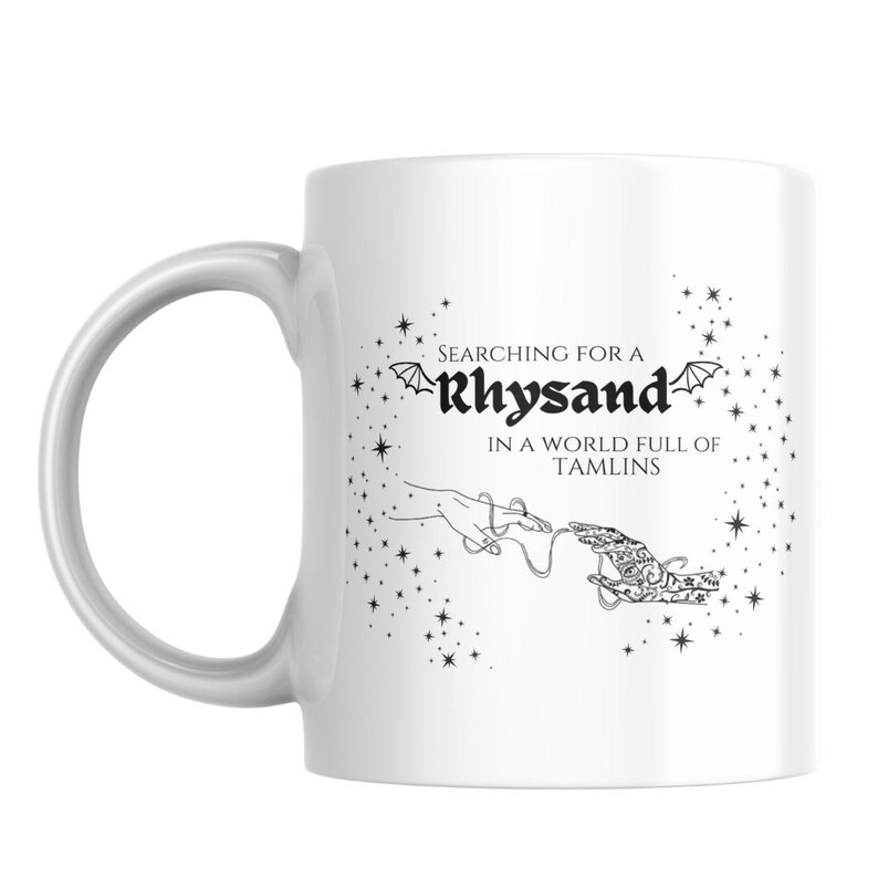 May include: White ceramic mug with a black and white graphic design. The design features a hand reaching out with a string attached to another hand. The text reads "Searching for a Rhysand in a world full of Tamlins".
