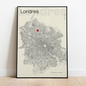 Puede incluir: Un póster enmarcado con un mapa en blanco y negro de Londres, con un punto rojo. La palabra "Londres" está arriba, con coordenadas abajo. El mapa está sobre un fondo crema.