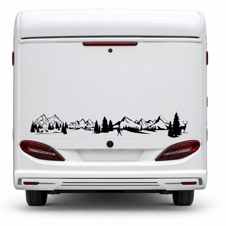 May include: A black vinyl decal applied to the rear of a white camper van. The design features a continuous landscape silhouette including jagged mountain peaks, dense pine forests, a lone hiker with a walking stick, and a standing deer.