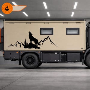 Puede incluir: Una furgoneta camper beige con una silueta negra de un lobo aullando sobre una cordillera. La furgoneta tiene dos ventanas y una parte inferior negra. El logotipo en la esquina superior izquierda muestra una persona con una mochila.