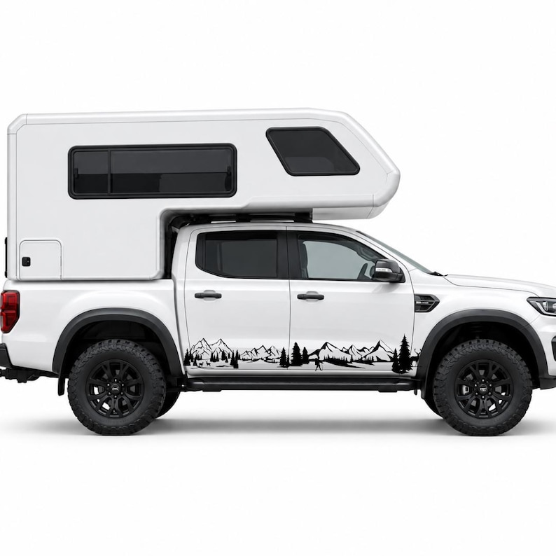 May include: A white pickup truck with a matching white camper shell features a black vinyl decal along the lower side panels. The decal depicts a detailed mountain range silhouette with evergreen trees, a small hiker, and wildlife.
