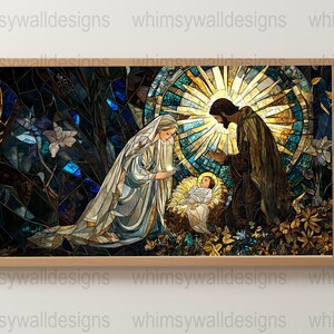 May include: A framed stained-glass style artwork depicting the Nativity scene. Mary and Joseph are kneeling, gazing at the baby Jesus in a manger. The artwork features a radiant sunburst and floral elements, with a color palette of blues, browns, and golds.