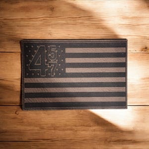 May include: A black and brown American flag doormat with the numbers "457" in the upper left corner.