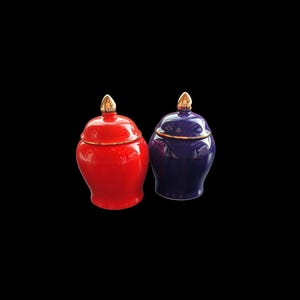 Puede incluir: Dos jarras de cerámica con tapa y detalles dorados. Una jarra es roja y la otra es azul.