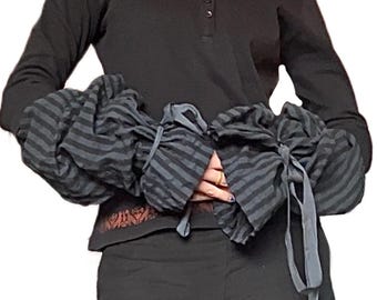 Camicetta eccentrica con maniche a sbuffo regolabili e decorazioni ispirate al folklore baltico.