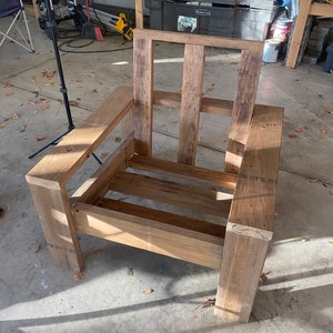 Puede incluir: Un marco de silla de madera con un acabado de madera natural. La silla tiene un dise&ntilde;o simple con un asiento y un respaldo rectangulares.