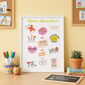 Op de afbeelding: Een ingelijste print met de Duitse tekst "Tägliche Affirmationen" en diverse affirmaties in het Duits. Het kunstwerk toont kleurrijke illustraties van bloemen, harten en een lachend gezicht. Een klein schoolbord met de tekst "KLASSENZIMMER HELDEN" is ook zichtbaar.