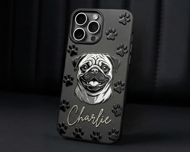 May include: A matte black smartphone case featuring a raised, monochromatic illustration of a pug's face in the center. The name Charlie is written in a white cursive script below the dog. The case is decorated with embossed paw prints.