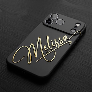 May include: A white ceramic mug with a black handle and the text "But First, Coffee" in a bold, black font. The mug is set against a blurred background, suggesting a cozy setting.