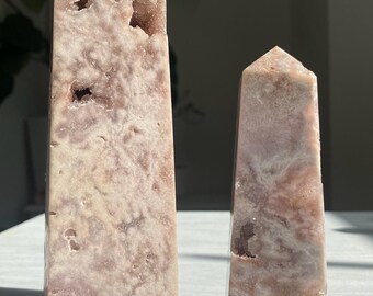 May include: Two pink amethyst crystal points, one larger than the other, with a white background. The larger point is labeled "A" and the smaller point is labeled "B".