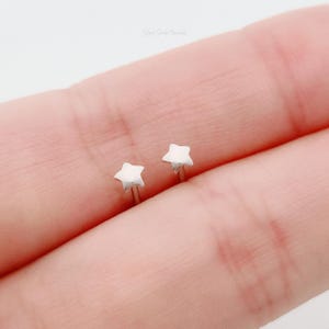 May include: A pair of silver star stud earrings. The earrings are small and delicate, and they are perfect for everyday wear.