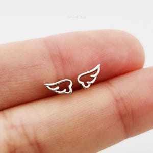 May include: A pair of silver angel wing earrings. The wings are small and delicate, and they are perfect for adding a touch of whimsy to any outfit.