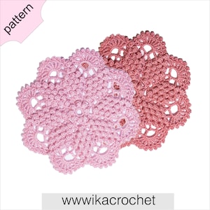 May include: Two crocheted doilies in pink and a darker shade of pink. The doilies are in the shape of a flower with multiple layers of crocheted stitches.