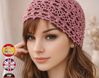 May include: A dusty rose crochet beanie featuring an intricate openwork lace pattern. The hat has a scalloped edge and a textured, lightweight construction. Three circular badges are present, labeled PDF ESPAÑOL PATRÓN, PDF ENGLISH PATTERN, and PDF DEUTSCHE MUSTER.