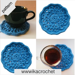 Op de afbeelding: Blauwe gehaakte onderzetters met een delicaat patroon. De onderzetters worden getoond met een zwarte koffiemok erop. De afbeelding bevat de tekst "pattern" en "www.wikacrochet".