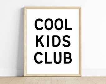 Peut inclure: Impression encadrée avec l'inscription « COOL KIDS CLUB » en lettres noires grasses sur fond blanc. Le cadre est en bois clair, posé contre un mur blanc et un sol en bois clair.