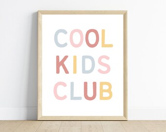 May include: A framed print with the text "COOL KIDS CLUB" in colorful letters. The letters are in shades of pink, blue, yellow, and red.