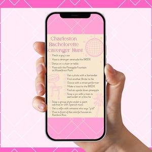 Puede incluir: Un teléfono inteligente que muestra una lista rosa de la búsqueda del tesoro de despedida de soltera de Charleston. La lista incluye tareas como tomar fotos y bailar. El teléfono se sostiene contra un fondo geométrico rosa y blanco.