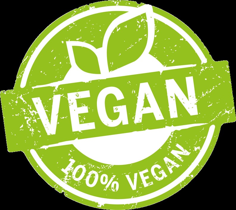 May include: A circular green and white emblem featuring a distressed texture. The design includes two stylized leaves at the top and a central horizontal banner with the word VEGAN in bold white capital letters. The text 100% VEGAN is printed below.