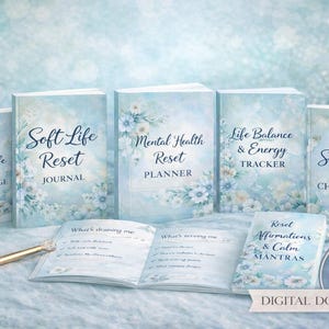Könnte beinhalten: Ein Bundle aus fünf Journalen und Planern mit floralen Designs und Titeln wie "Soft Life Reset Journal" und "Mental Health Reset Planner". Die Journale sind hellblau mit weißen floralen Akzenten und einem goldenen Stift. Das Bundle ist als "5-IN-1 BUNDLE" gekennzeichnet.