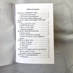May include: Open book with a table of contents titled "Table of Contents". The contents include sections on runes, including introduction, how to work with the deck, depth of runes, practice, and combinations.