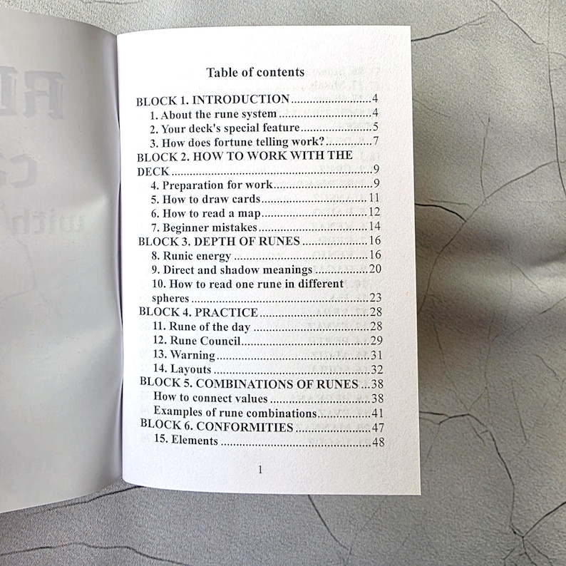May include: Open book with a table of contents titled "Table of Contents". The contents include sections on runes, including introduction, how to work with the deck, depth of runes, practice, and combinations.